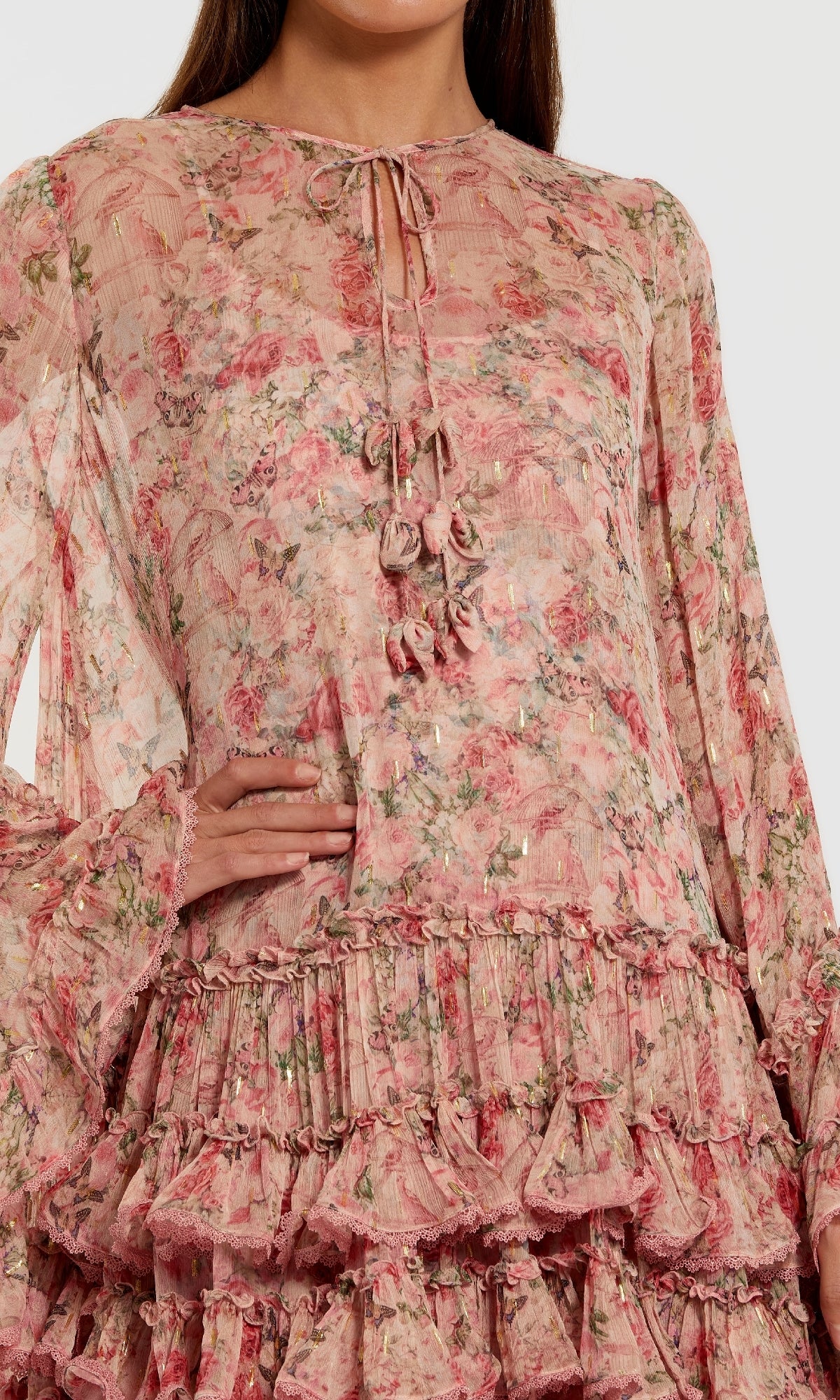 A woman wearing the Mac Duggal 8336 Print Short Wedding Guest Dress—a floral long-sleeved pink dress with ruffle details and a tie-front neckline, perfect for wedding guests.